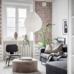 Un luminoso apartamento escandinavo con paredes de ladrillo a la vista.
